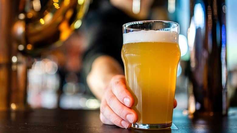 Bartender serving beer over bar
