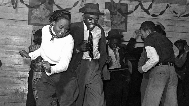 A well dressed couple dancing at a juke joint