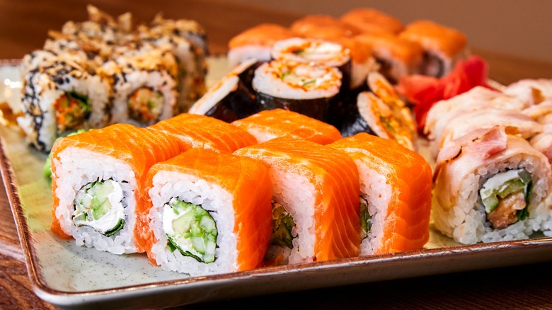 Various sushi rolls on light colored tray