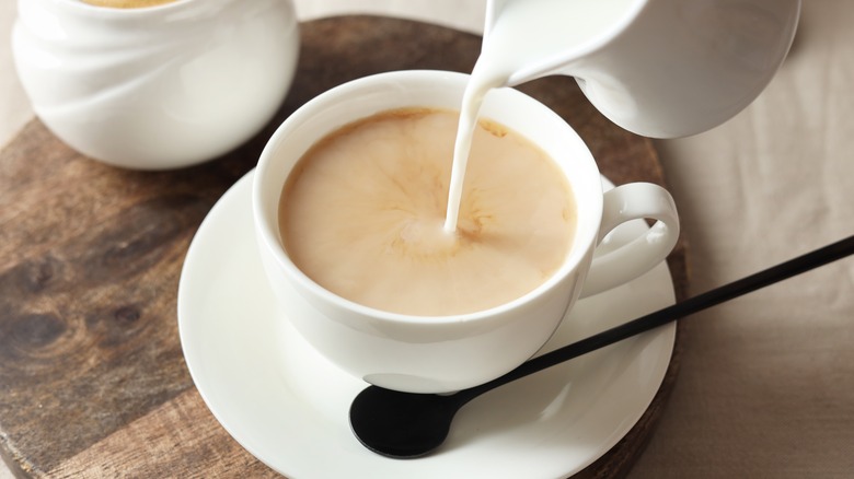 pouring milk into tea