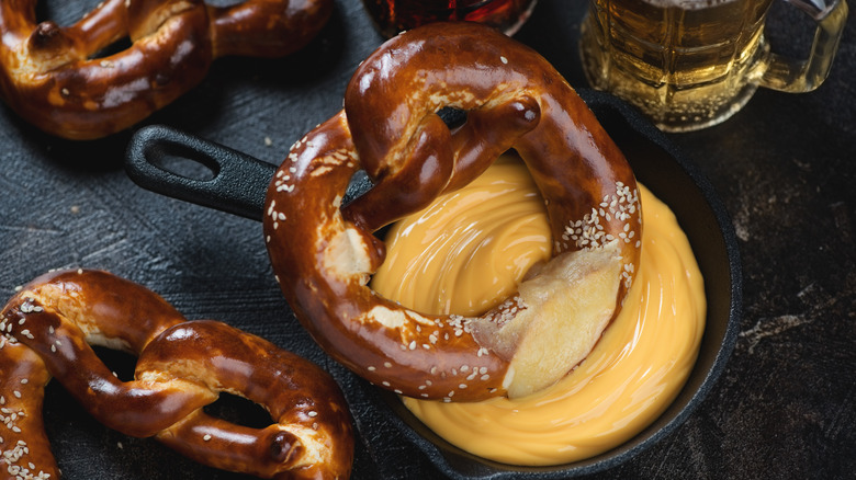 A pretzel dipped in beer cheese.
