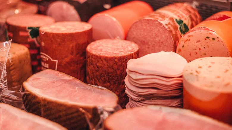An arranged array of sliced and uncut deli meats