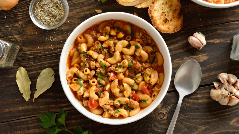 Bowl of American goulash with herbs and toasted bread