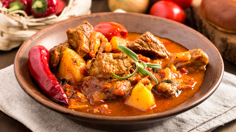 A bowl of Hungarian goulash with chunks of meat, potatoes, and broth
