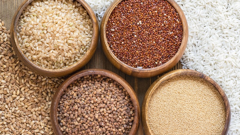 Various ancient/whole grains in wooden bowls.