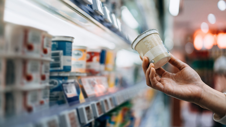 A person shopping for yogurts