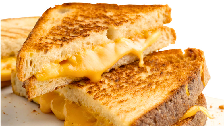 Grilled cheese sandwich cut diagnolly with cheese oozing out