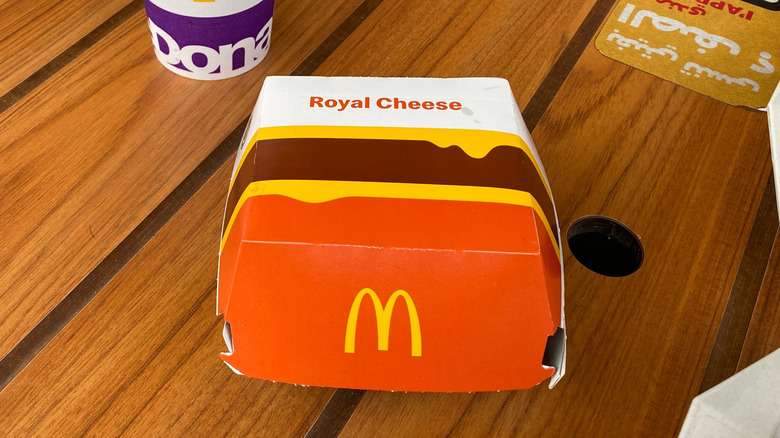 A McDonald's box for a Royal Cheese sitting on a dining room table.
