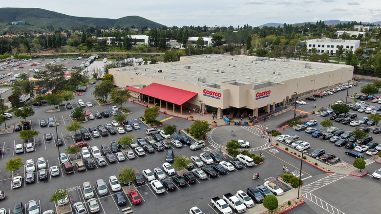 An aerial view of a Costco warehouse with a large parking lot out front loaded up with cars.
