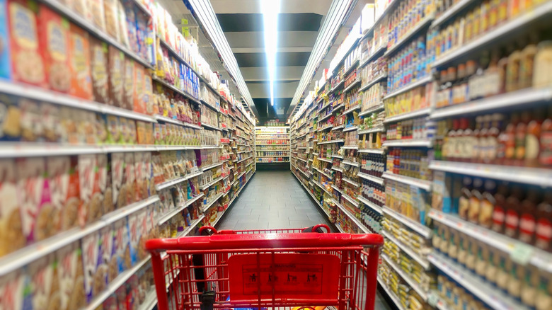 An aisle in a supermarket with the top of a shopping cart