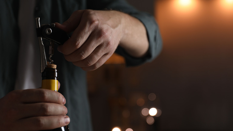 A man opening a bottle of wine