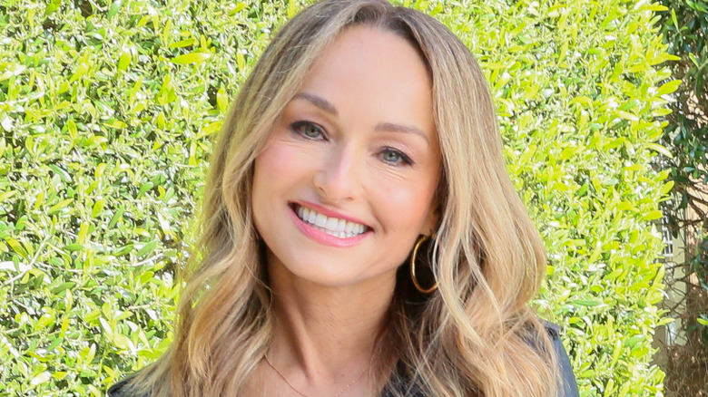 Giada De Laurentiis smiling in front of green bush