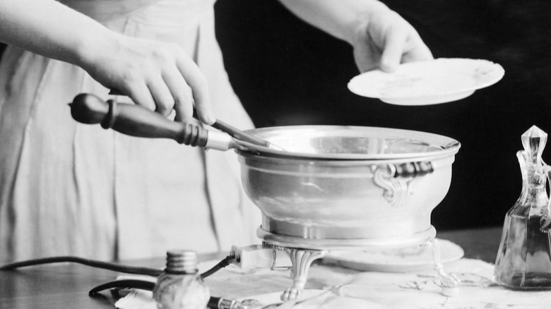 vintage photo of person cooking with chafing dish