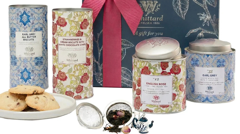 Tubes of biscuits and tins of tea with a gift box behind them