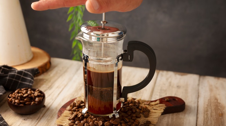 hand pushing plunger on French press