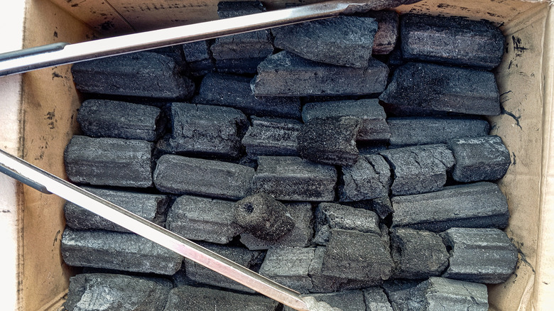 A cardboard box filled with charcoal briquettes