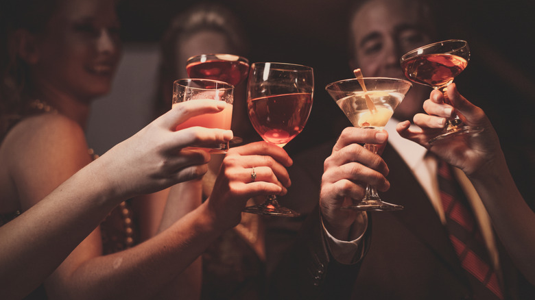 Four friends cheers their cocktails and wine