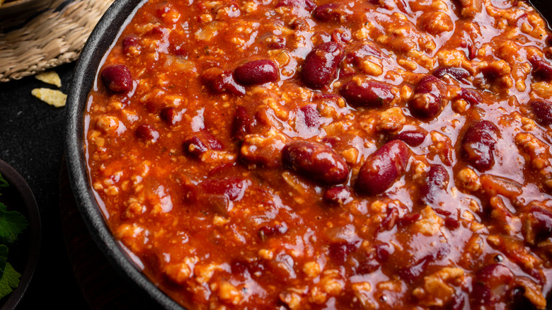 Hot chili with beans in a black pot.