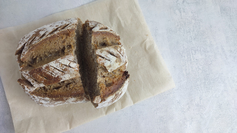 round loaf of whole wheat sourdough bread on a beige napkin