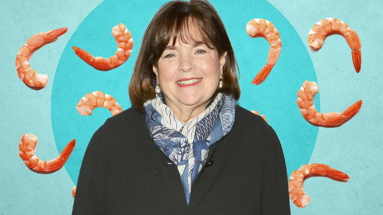 Ina Garten smiling with blue background and cooked shrimp