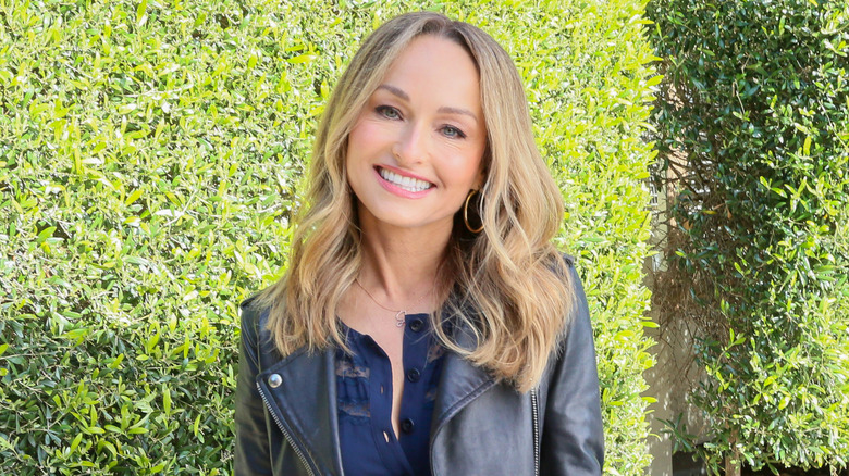 Giada De Laurentiis smiling in front of green bush