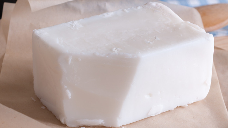 A solid block of tallow on parchment paper.