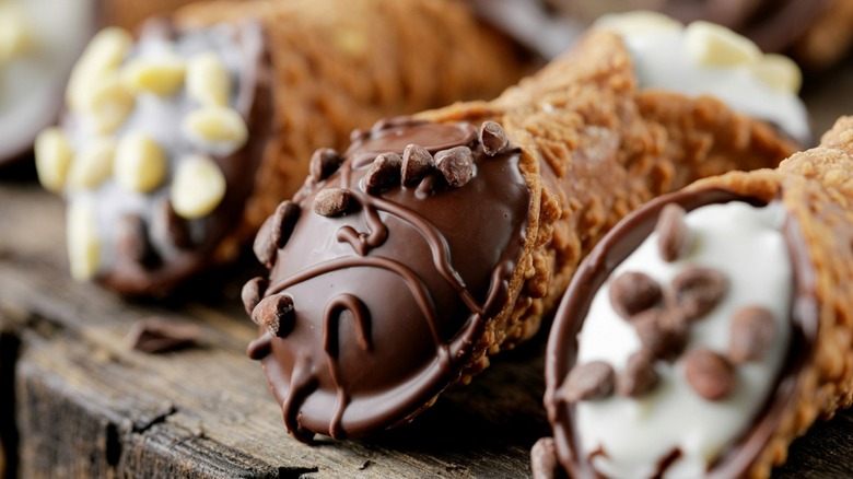 Cannoli with various fillings on a wooden serving board