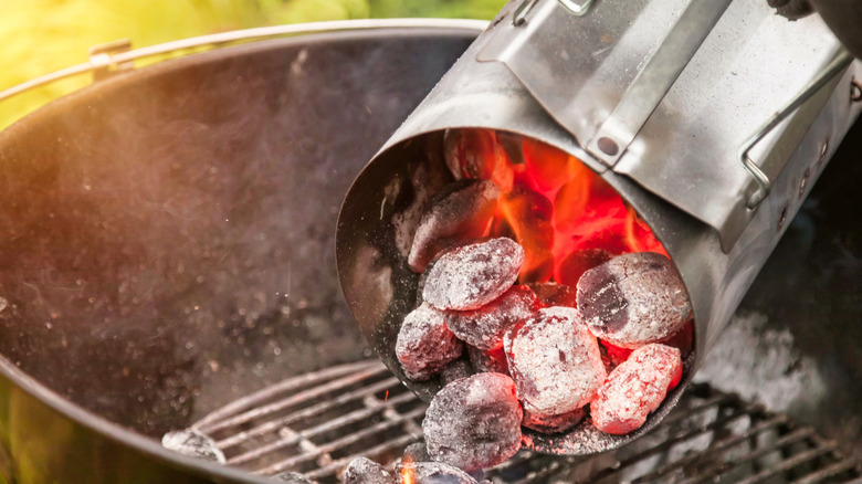 Glowing hot charcoal dumped into outside grill