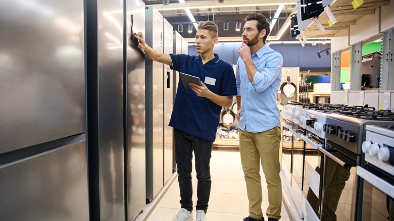 Person being assisted by store clerk while shopping for kitchen appliance
