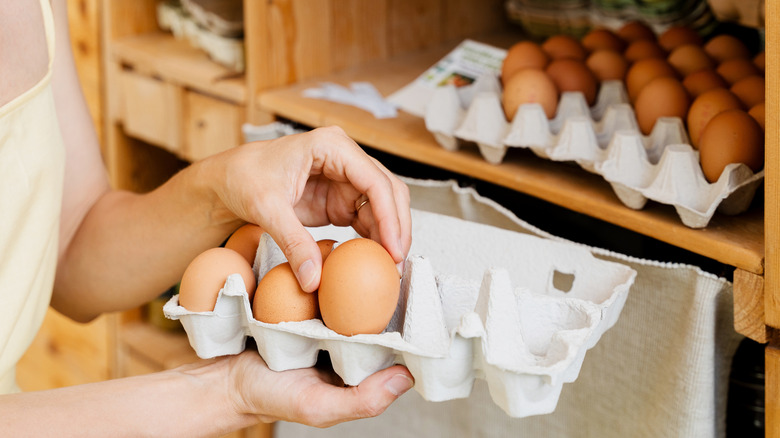 A woman holding an egg carton