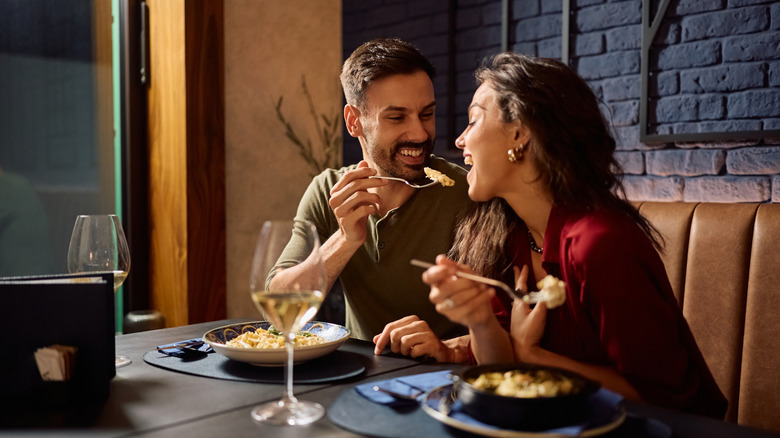 A couple eating pasta together in a restaurant