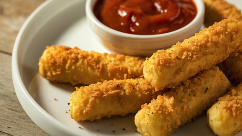 A plate of mozzarella sticks with marinara dipping sauce