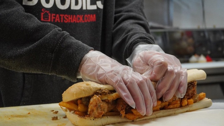 Someone at Fat Shack wrapping a sandwich