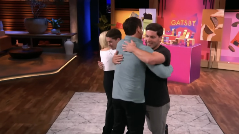 Gatsby co-founders hugging Mark Cuban and Lori Greiner after securing a deal.