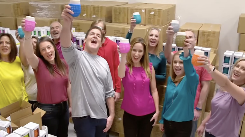 Mark Cuban raising a Goverre cup with co-founders Regan Kelaher and Shannon Zappala and their factory employees.