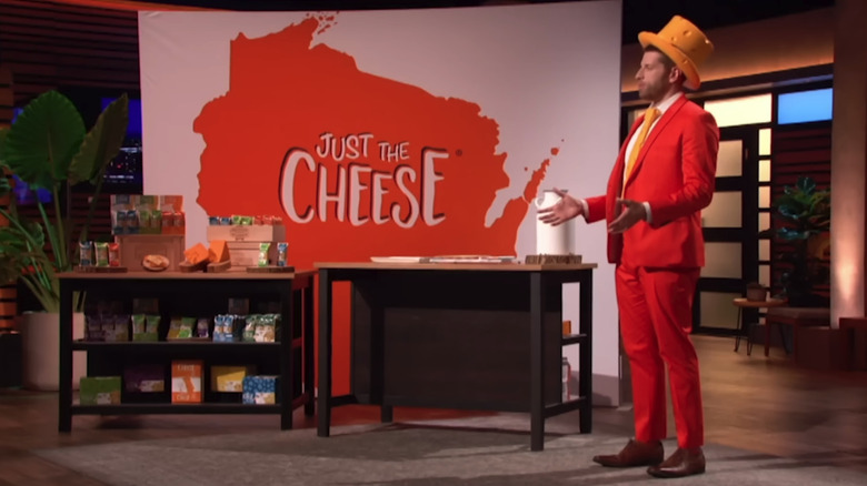 Clad in a cheese-inspired tuxedo and tie, Just The Cheese CEO David Scharfman stands in front of the Sharks during his pitch.