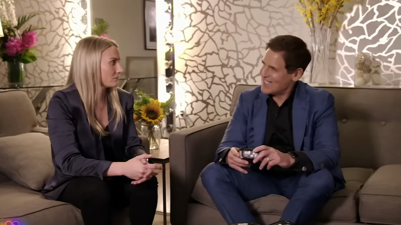 Ashley Thompson and Mark Cuban discussing the progress of MUSH so far while sat on separate couches.