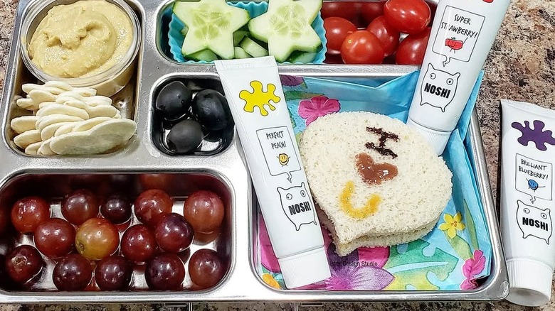 A school lunch with bread painted with three tubes of Noshi