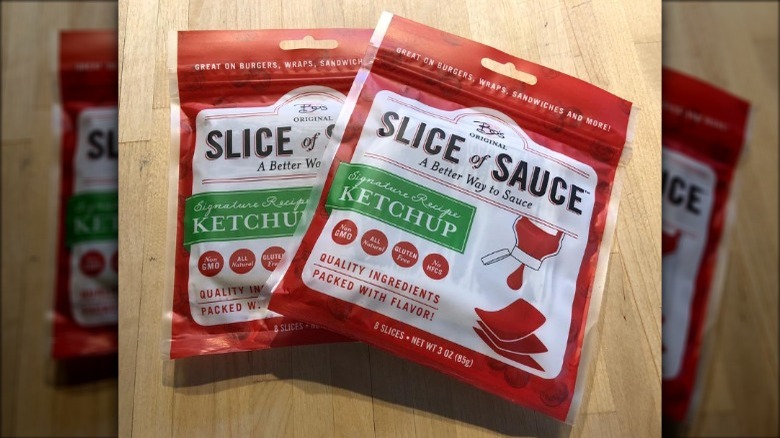 Two Slice Of Sauce packets piled on a table.