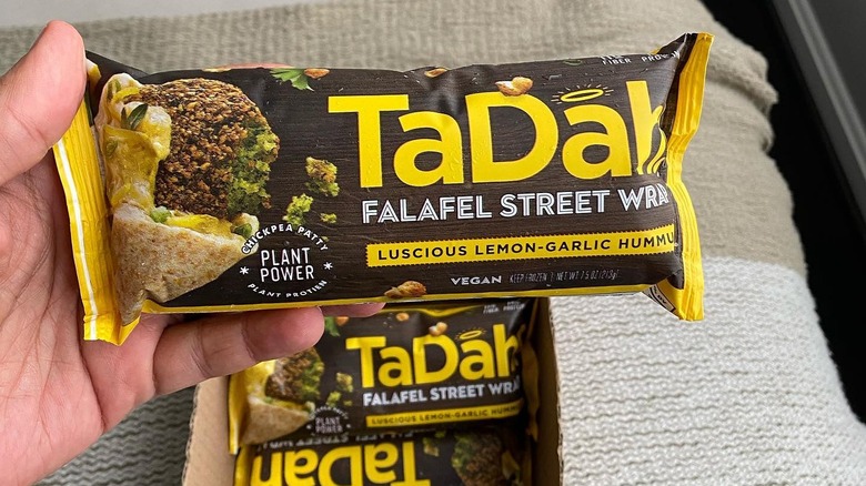 A TaDah falafel street wrap in yellow packaging.