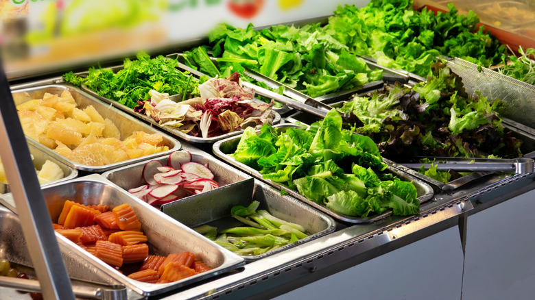 Salad bar with various vegetables and lettuces
