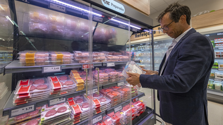 A man checking the label on a package of meat