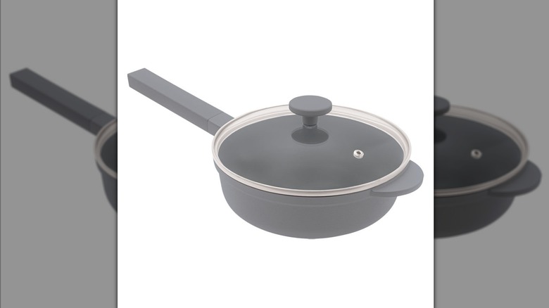 The gray Crofton Mini Awesome Pan with a glass lid on top of it