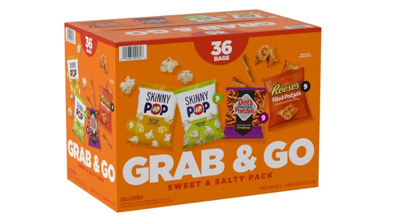 An orange box of Sweet and Salty Grab and Go Variety Snack Pack featuring SkinnyPop, Dot's Homestyle Pretzels, and Reese's
