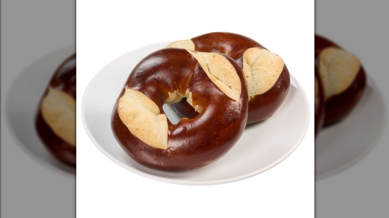 Two of the Kirkland Signature pretzel bagels from Costco on a white plate on a white background.