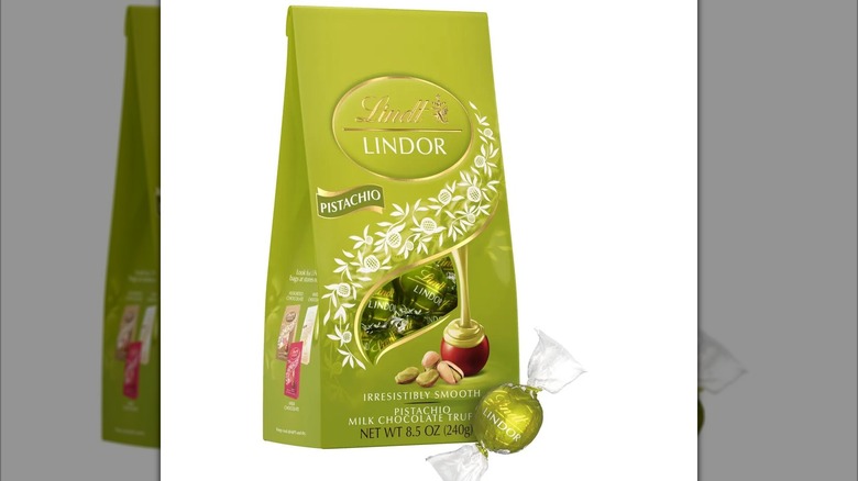 Bag of Lindt Lindor pistachio milk chocolate truffle with one piece at the bottom corner
