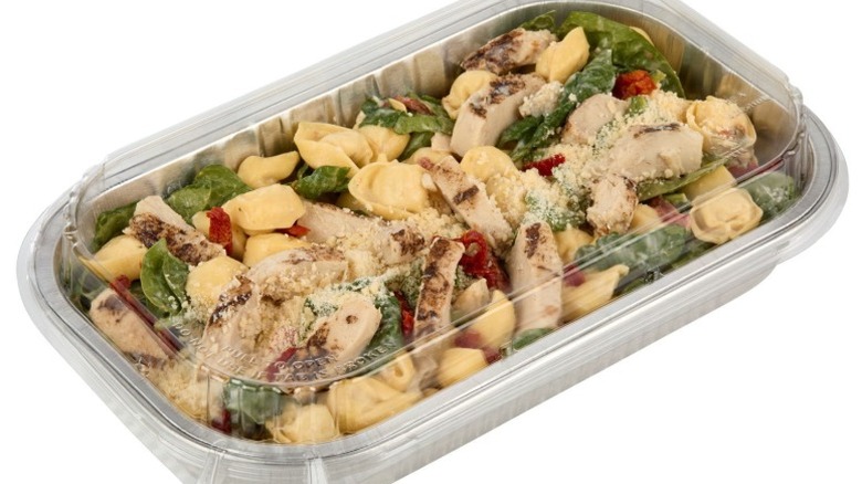 Member's Mark Marry Me Chicken with Tortellini in a foil pan with a clear plastic lid on a white background.
