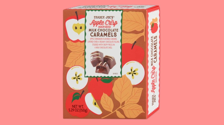 A box of the Apple Crisp Milk Chocolate Caramels sold at Trader Joe's on a pink background.