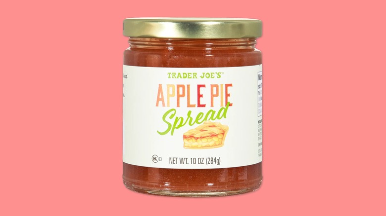 A jar of Trader Joe's Apple Pie Spread on a pink background.