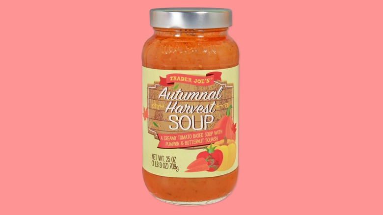 A jar of the Trader Joe's Autumnal Harvest Soup on a pink background.